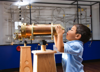 Child looking through telescope